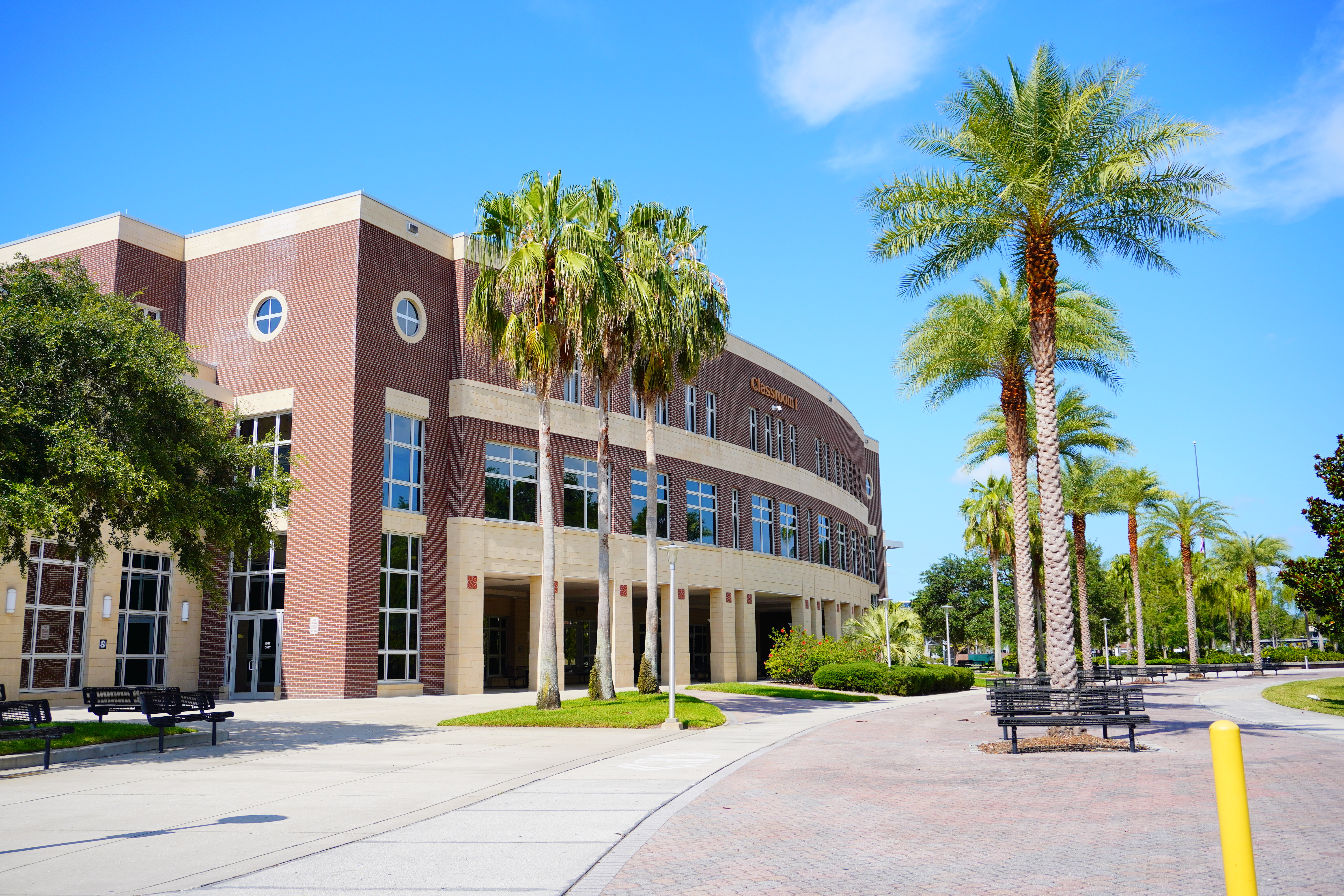 Building at the University of Central Florida with palm trees around benches