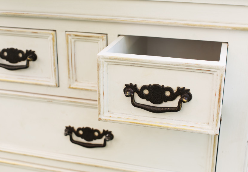 White dresser with one drawer pulled open and empty