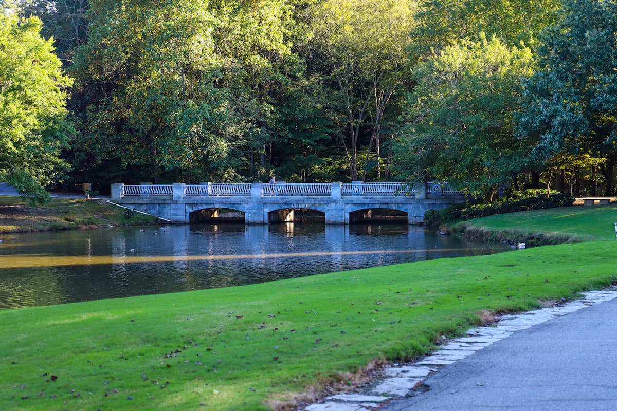 ornate concrete bridge over water in park