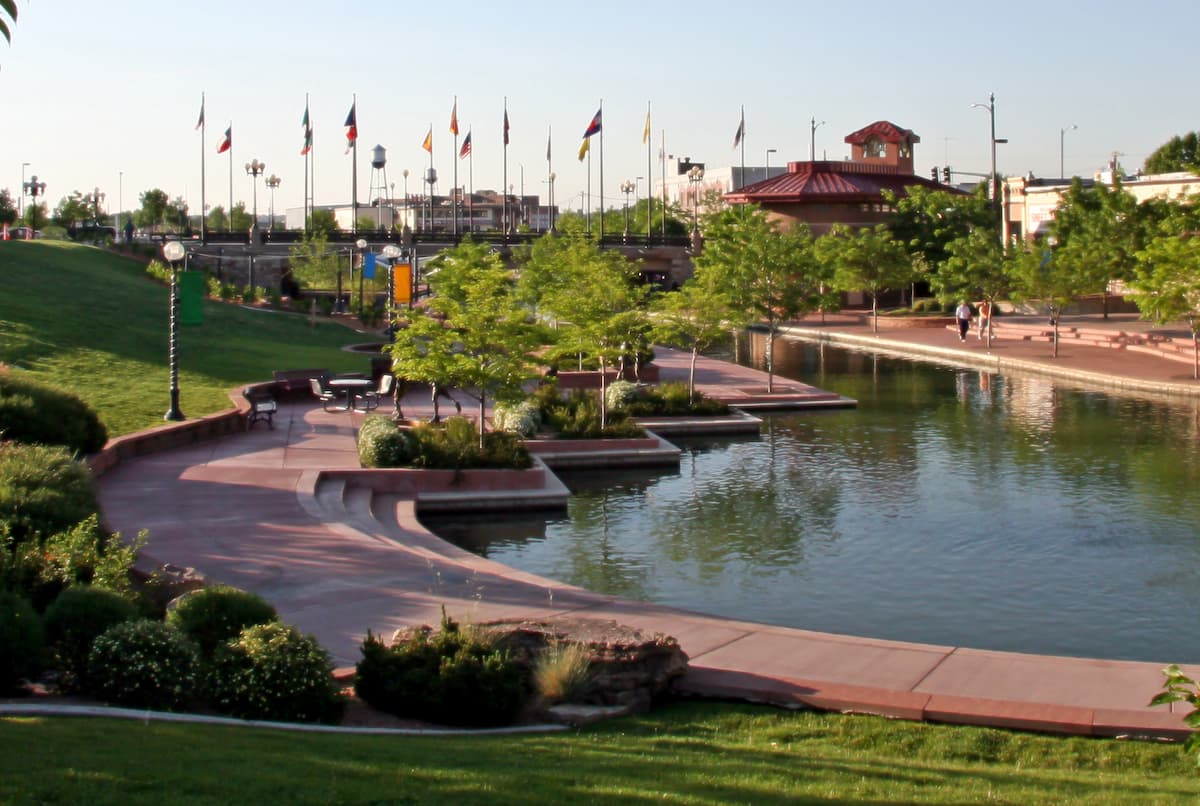 well-manicured Pueblo Riverwalk with flags waving and water