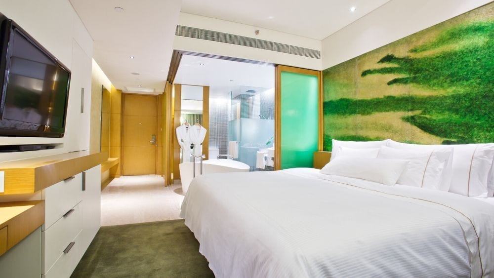 hotel bedroom with green walls and a white bed