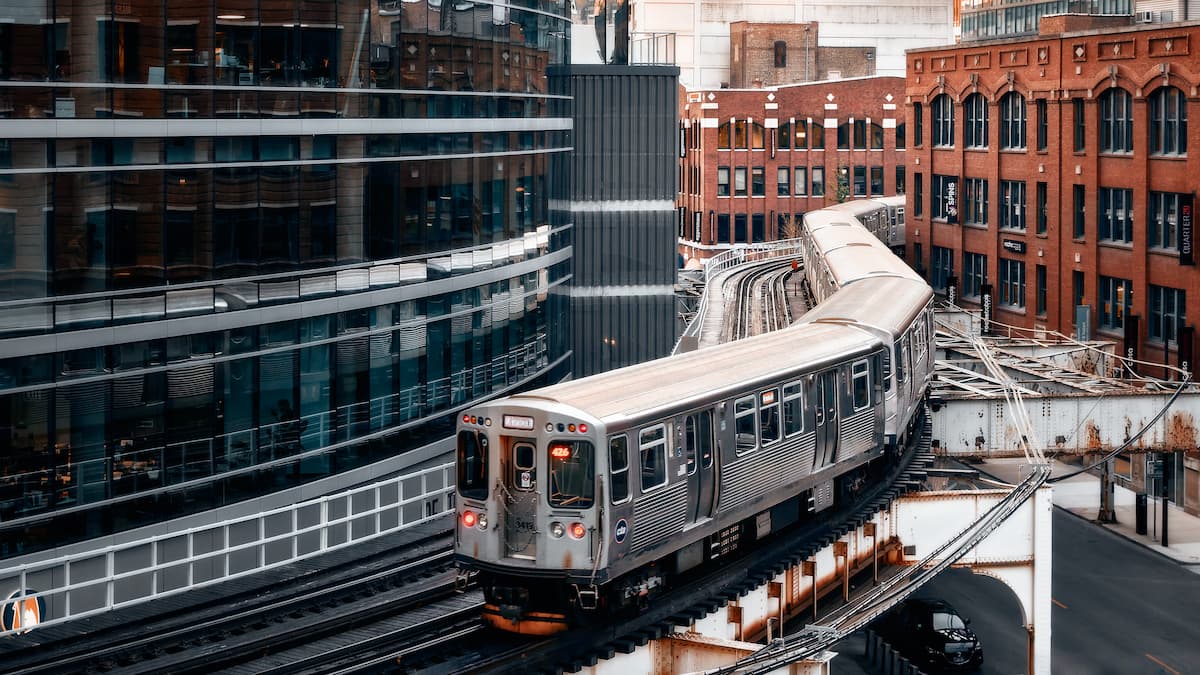 elevated train going between high-rise buildings in the city