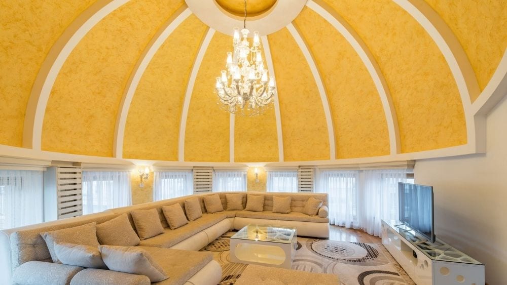 A living room with a large sectional and a yellow dome ceiling.