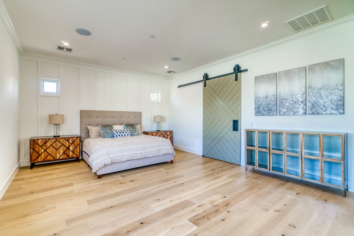 bedroom with light, wide natural colored hardwood flooring
