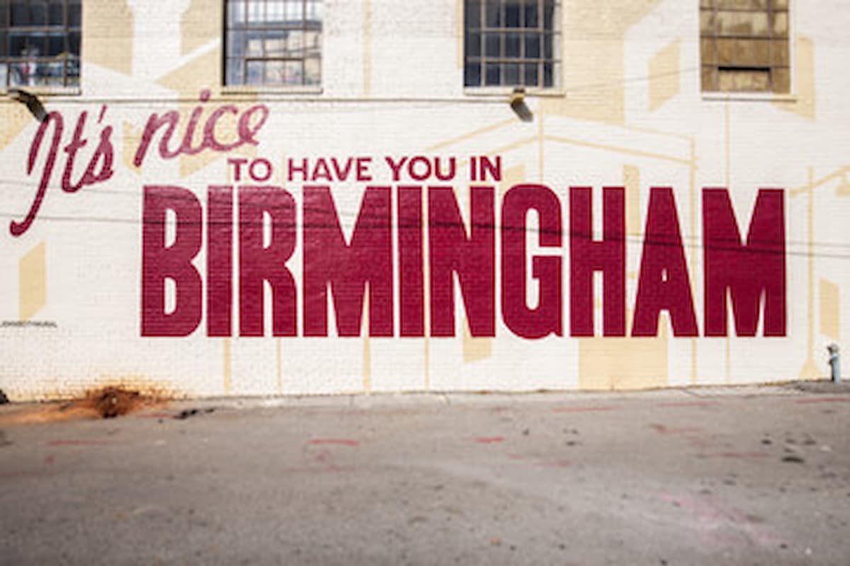 It's Nice to Have You in Birmingham mural with red letters painted on the side of a white building