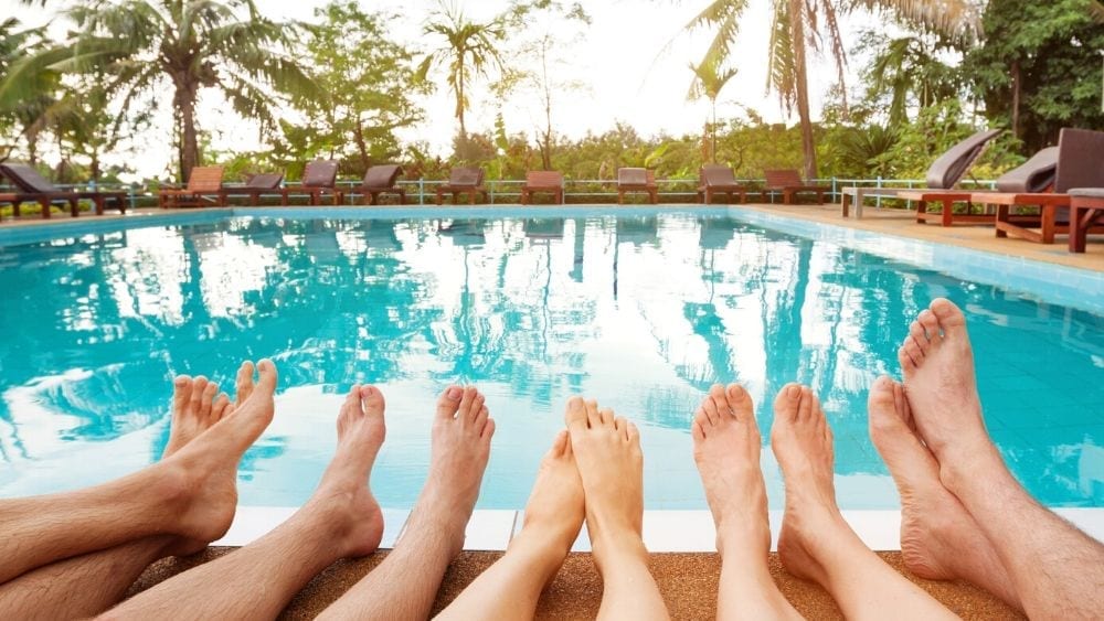 five pairs of feet on the edge of a pool