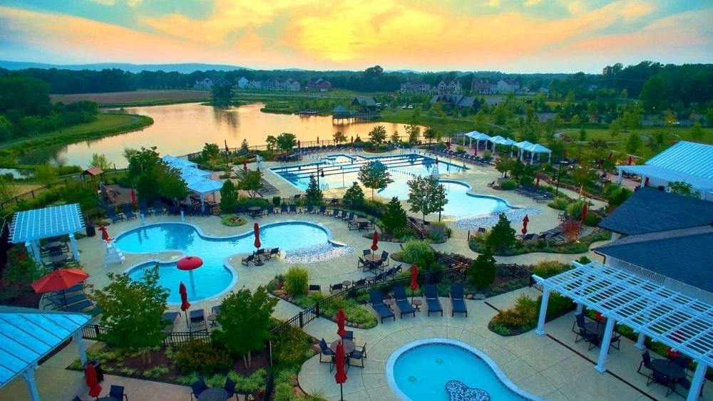 Overview of community pools and a lake at sunset.