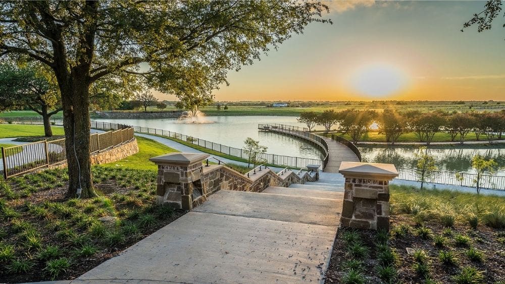 Sidewalks winding around trees and lakes at sunset.