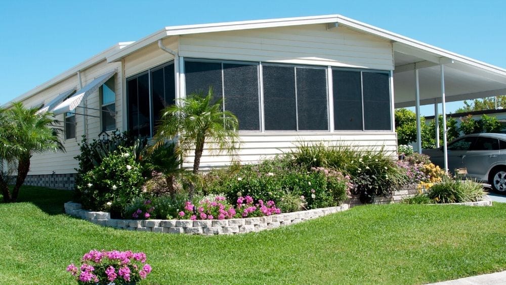 manufactured or mobile home with side porch and awning and garden in front