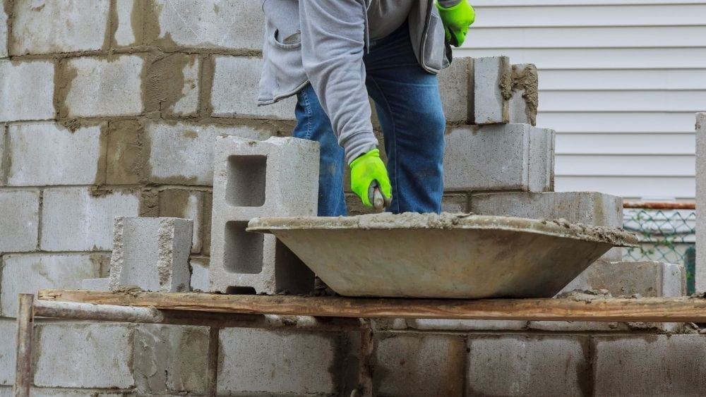 Worker laying cinderblock.