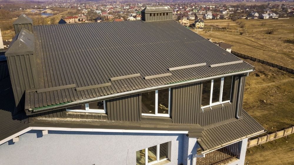 A house with stucco and metal walls and a metal roof.