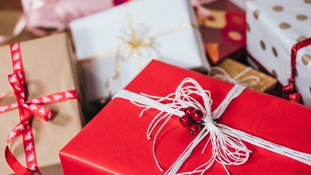 Several wrapped gift boxes decorated in red, beige, gold, and white.