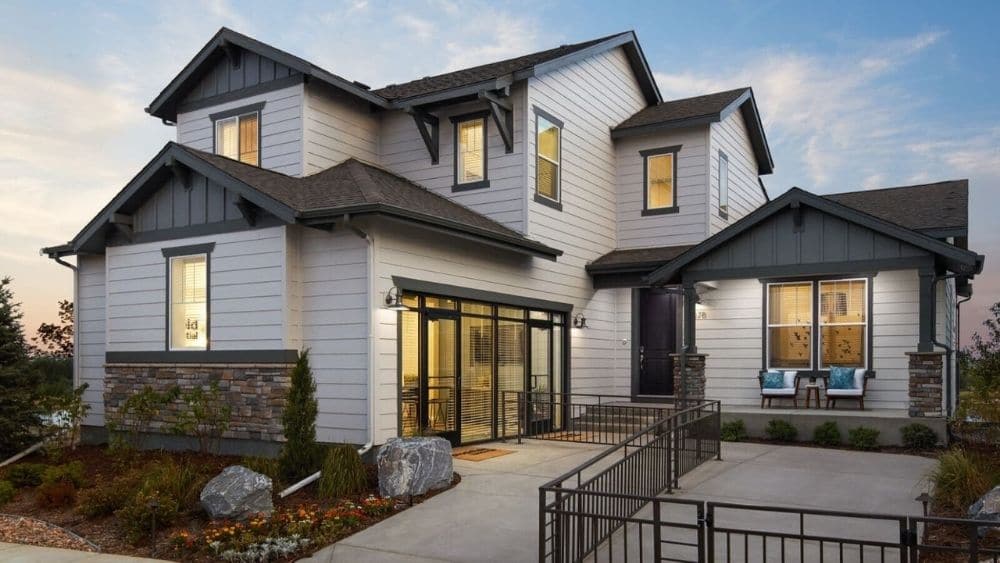 A modern two-story home with various rooves and large, black-framed windows.