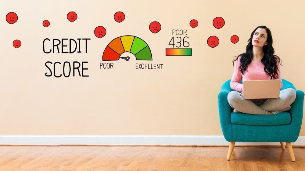 A woman sitting cross-legged on a chair looking at the wall, with graphics representing poor credit score