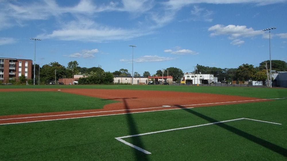 An empty, well-maintained baseball field on a clear day.