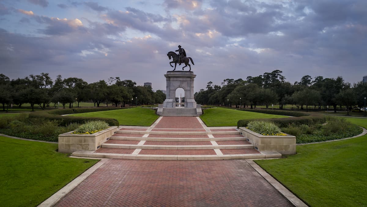 Statue of a man on a horse in Hermann Park in Houston on a well manicured circular mound
