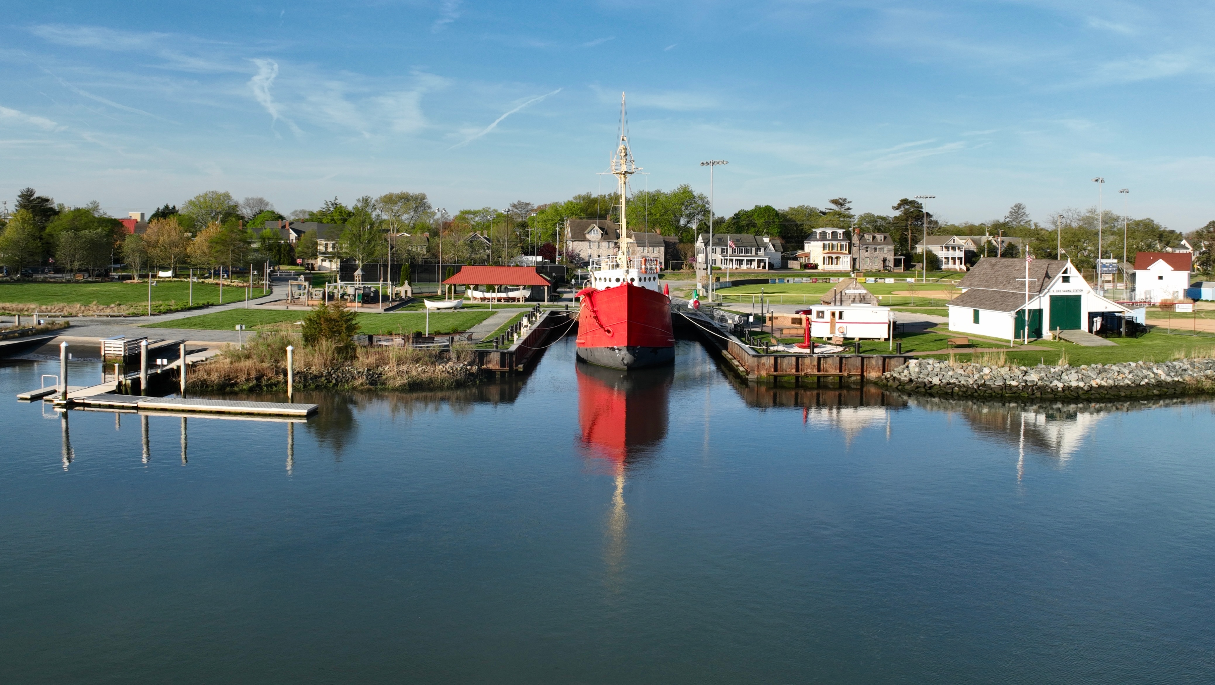 canal view with park and small ship in marina slot and homes in background