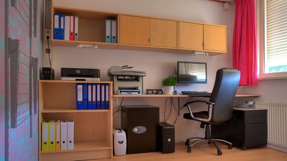 Wall-mounted desk with cabinets above and a half bookshelf.