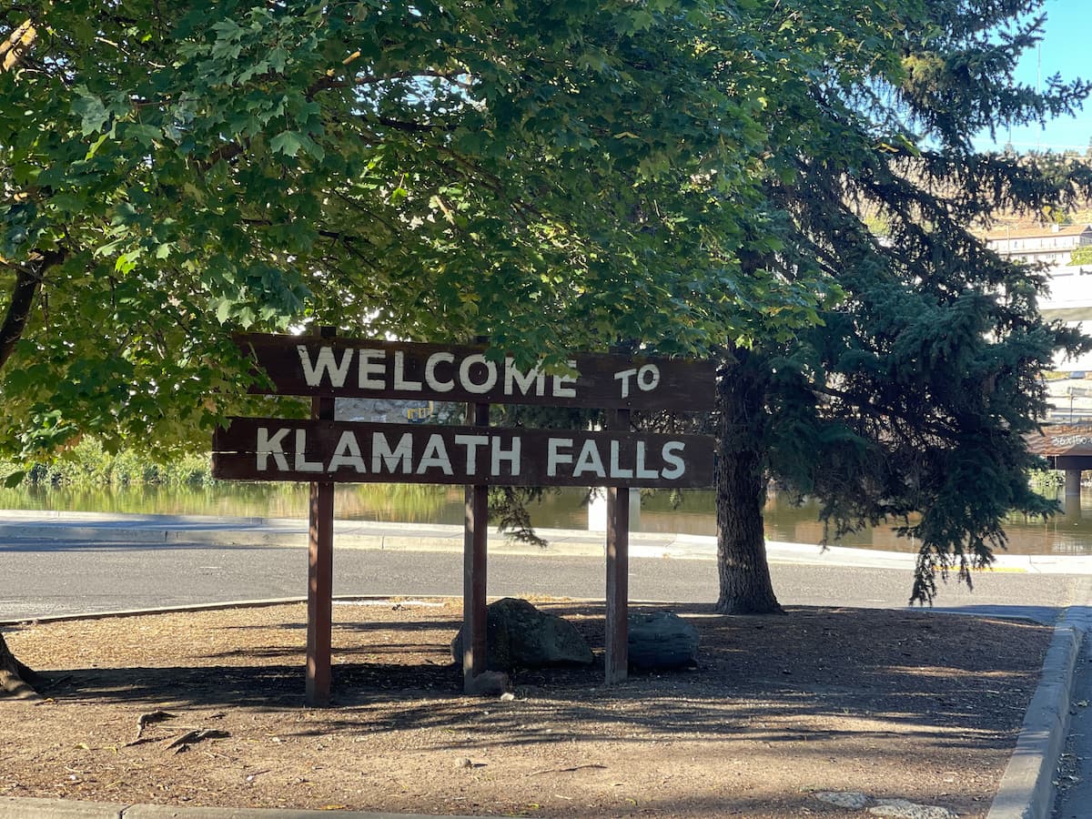 wood welcome to klamath falls sign under some trees