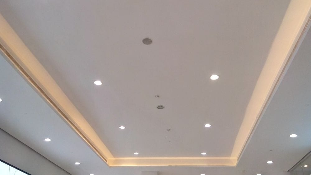 A cove ceiling with recessed lighting.