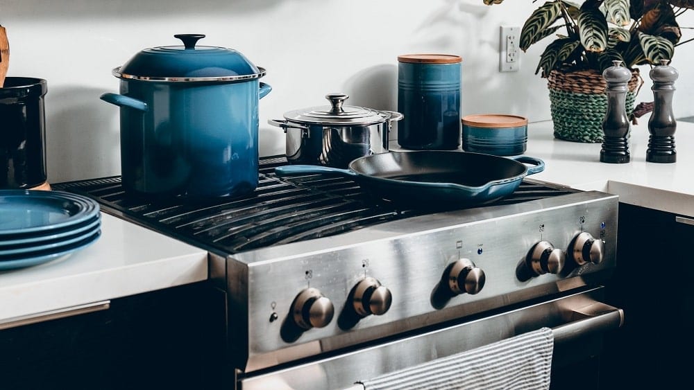 Kitchen with silver oven and blue cooking accessories.