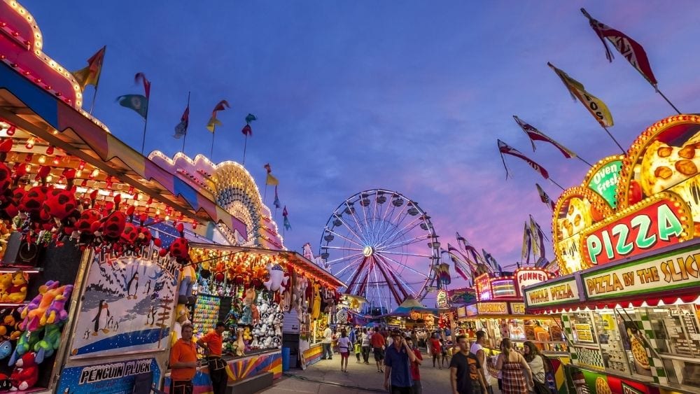 A bright city fair, lit up against an evening sky.