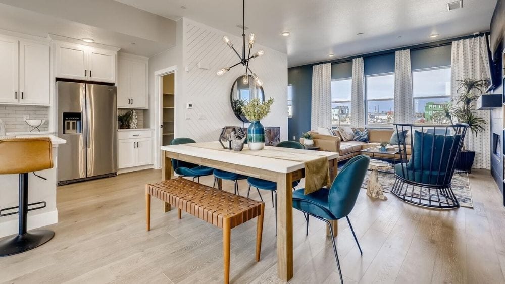 Open concept dining and living space with modern furniture and blue accents.