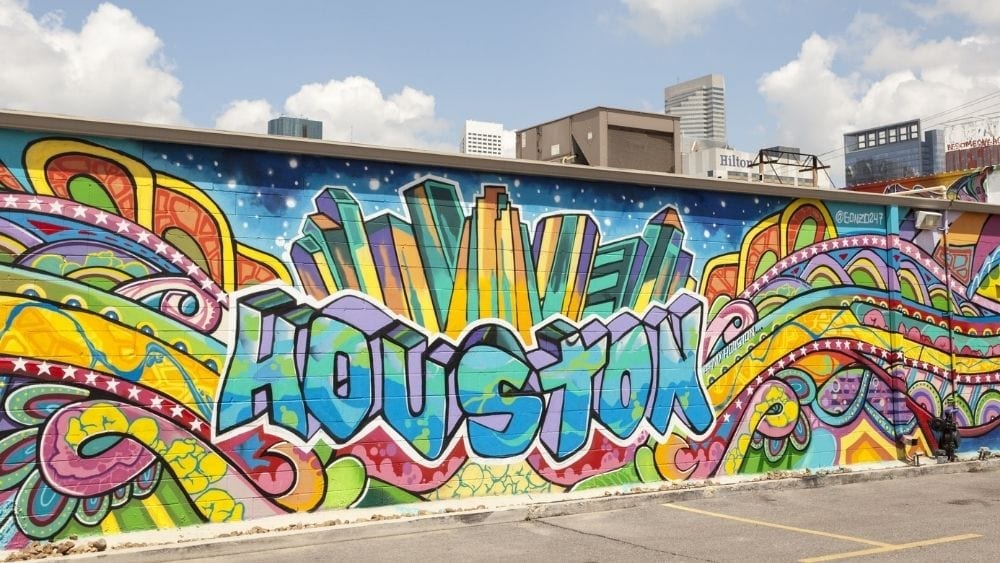 Colorful graffiti on the side of a building that reads “Houston” in blocky letters.