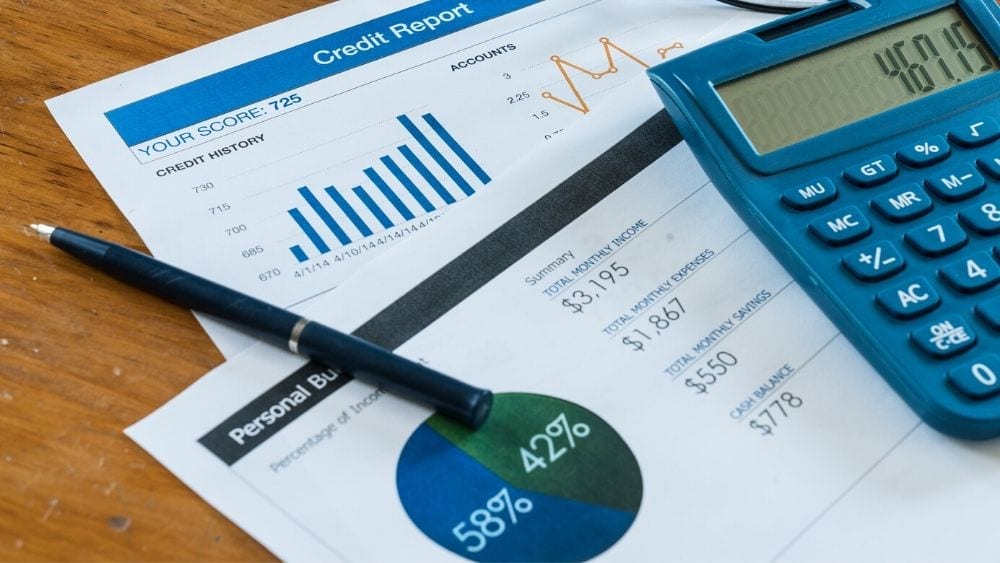 credit report with blue calculator and pens