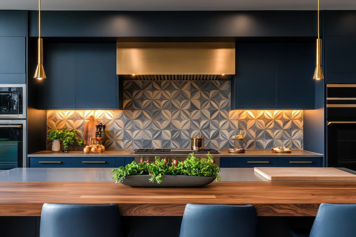 Blue kitchen cabinets with mosaic backsplash and bronze pendant lighting, bronze range hood