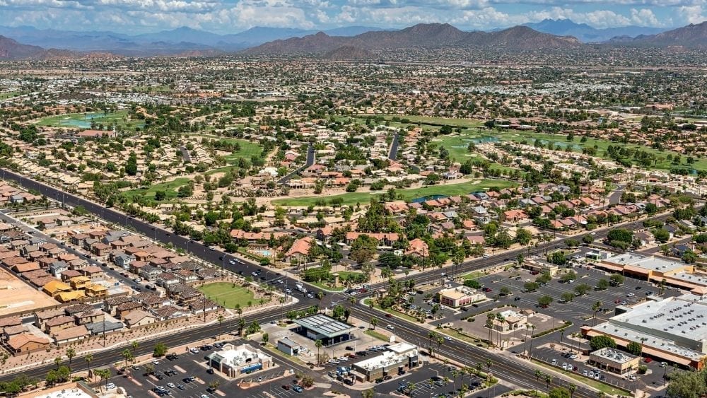 An aerial view of a densely populated area with lots of houses and shopping centers.
