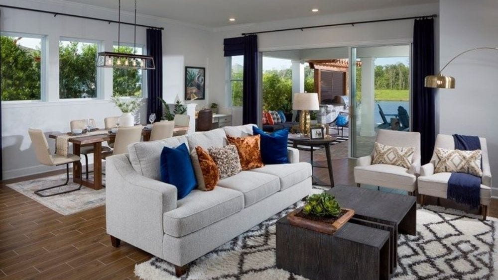 Modern living room with a white couch and colorful pillows.