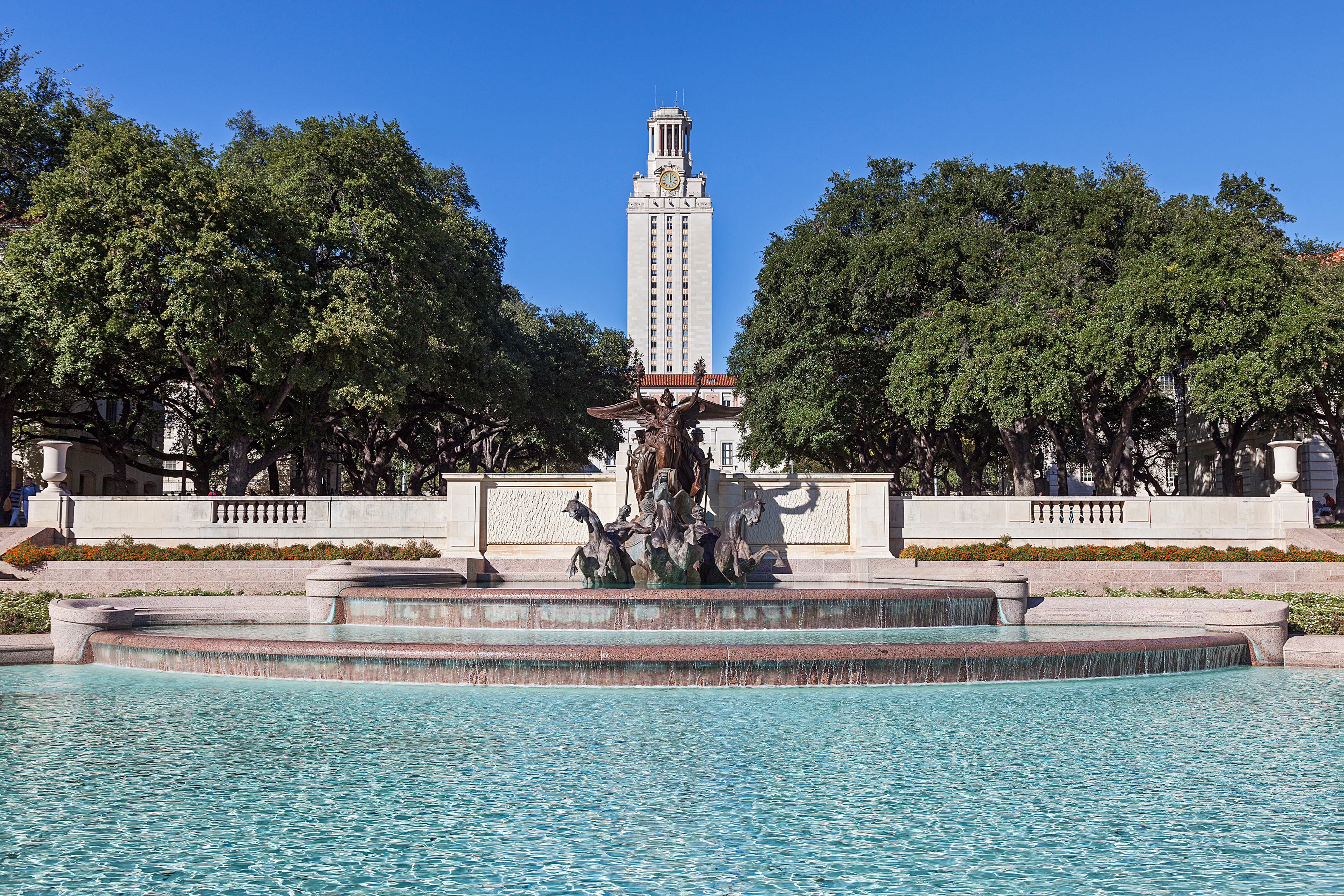 water cascading in a fountain with university building in the background