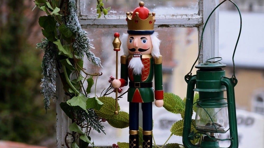 Multicolored nutcracker next to green lantern.