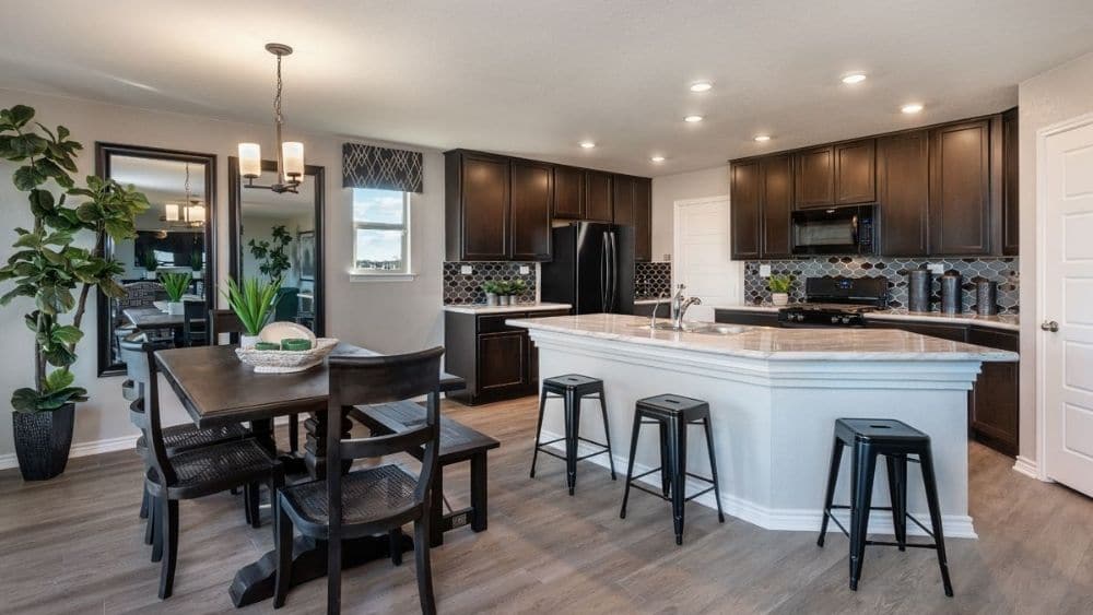 A modern kitchen with an island and dark cabinets.