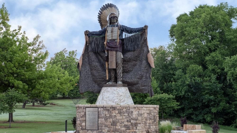 A detailed statue on a stone base of an Indigenous chief.