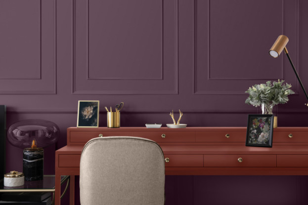 Purple wall with panelling, with a red desk in front, with a white chair