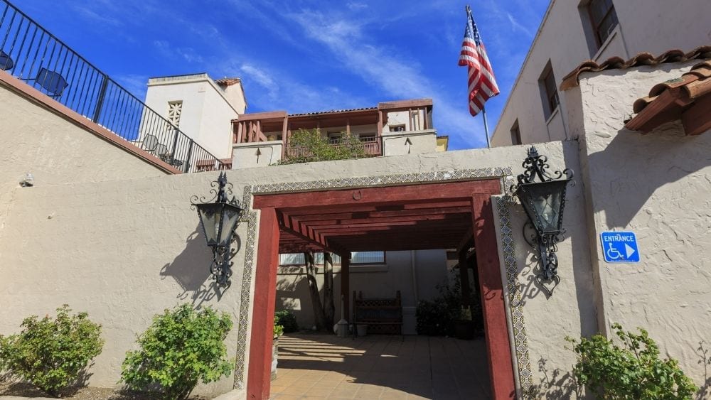 A Spanish-style building with white stucco walls and red trim.
