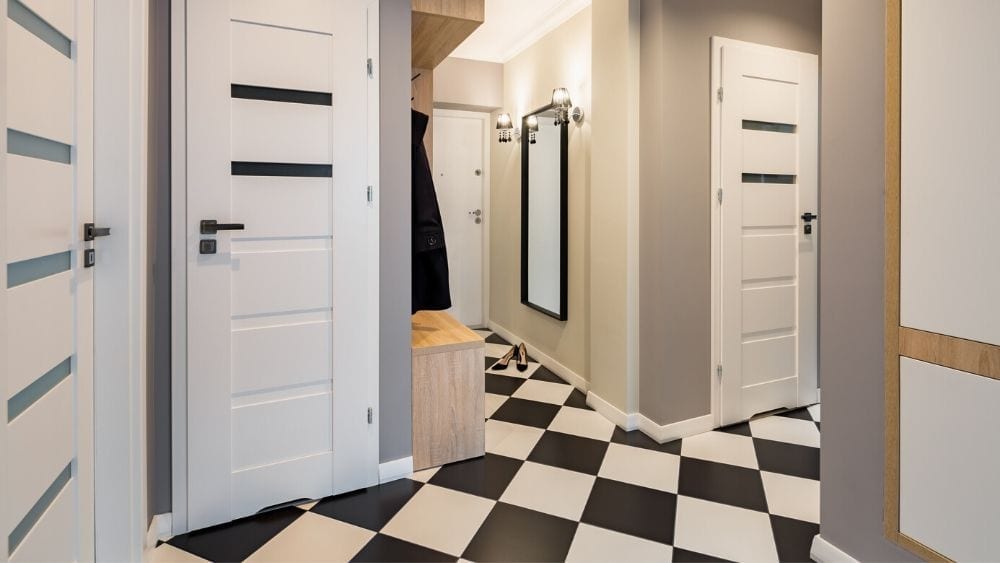 black and white checkered floor with white doors and tan walls