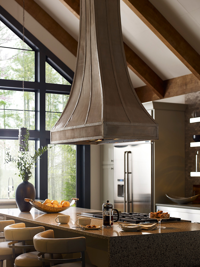 Custom range hood in burnished nickel, in a wood, Farmhouse-style kitchen, with island, and lots of natural light