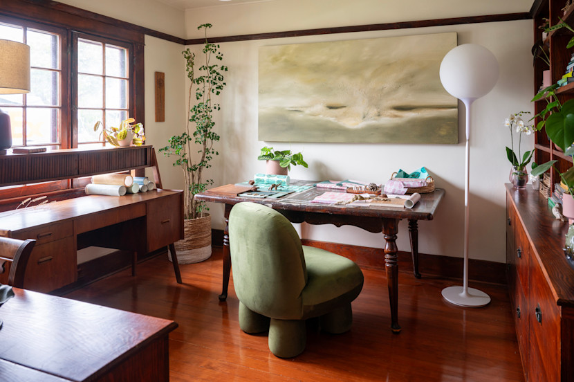 Home office in a restored Craftsman home, with wood floors, wood furniture and round green chair