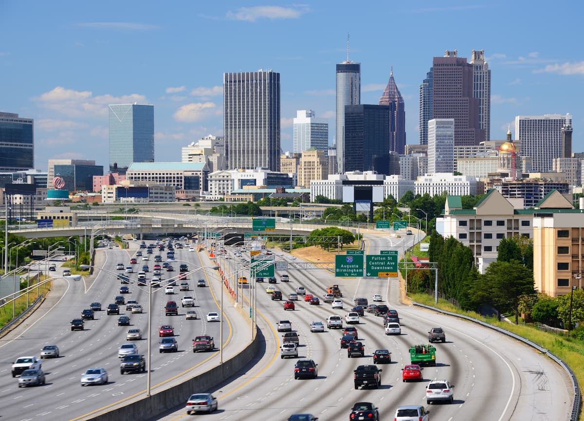 view through the trees of Atlanta traffic with downtown skyscrapers in the background