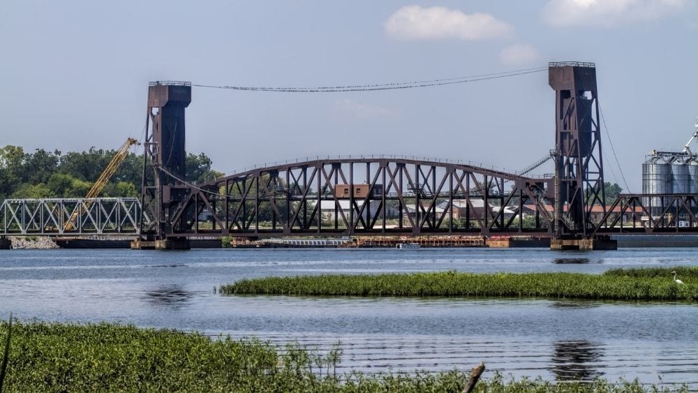 An old, dark drawbridge over a wide river.
