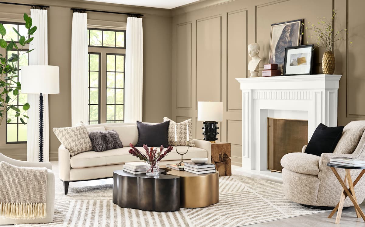 A living room painted with Sherwin-Williams and HGTV Home by Sherwin-Williams Paint Color of the Year Universal Khaki, which is a mid-tone tan, with yellow undertones