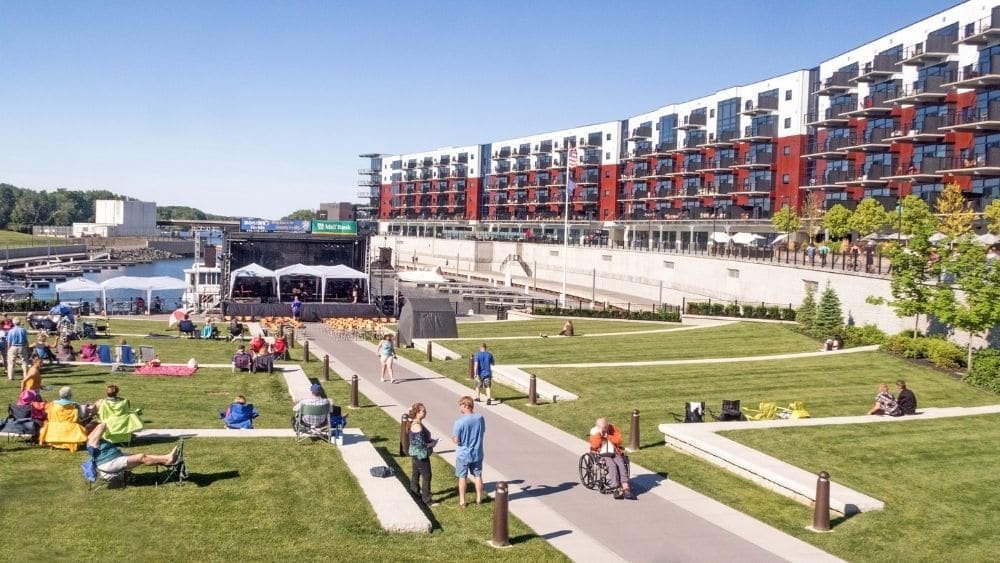Apartments and greenspace with people hanging out in Schenectady, New York.