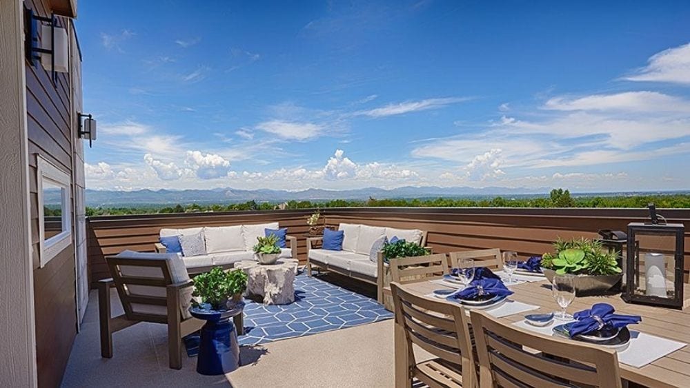 A furnished balcony overlooking a mountain range.