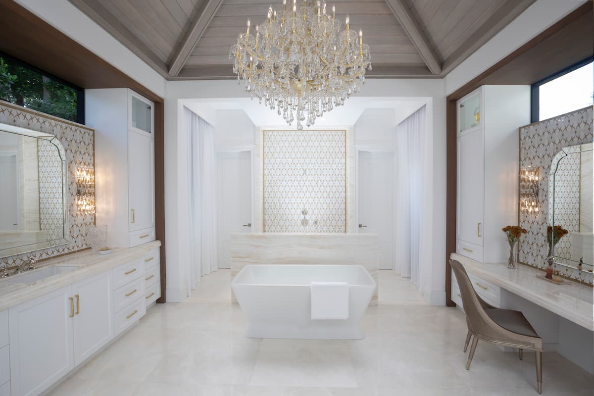 Bathroom done in transitional style, with crystal chandelier, wood trim and deep white soaker tub