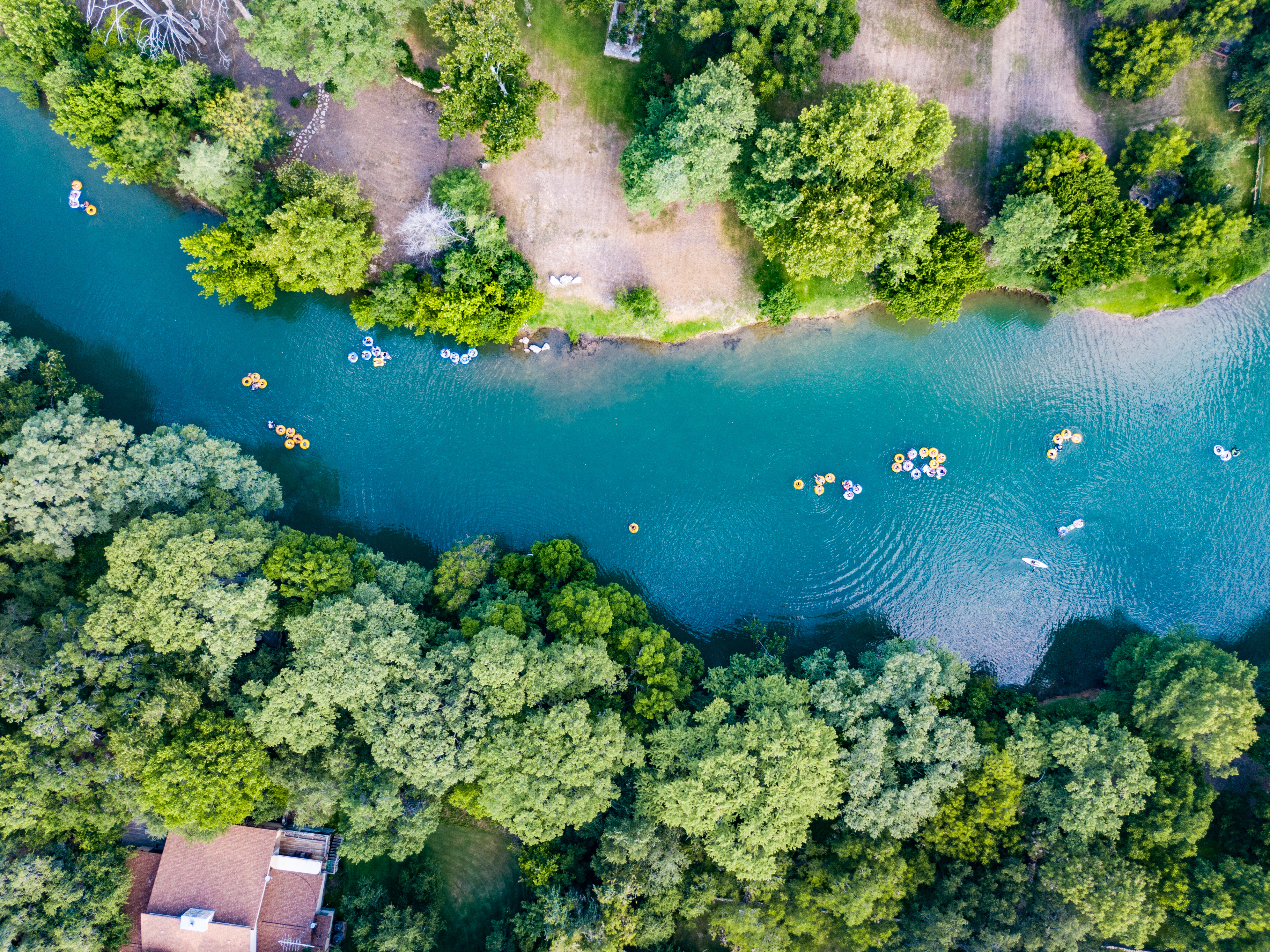 aerial view of tree lined Guadalupe River with people floating on tubes