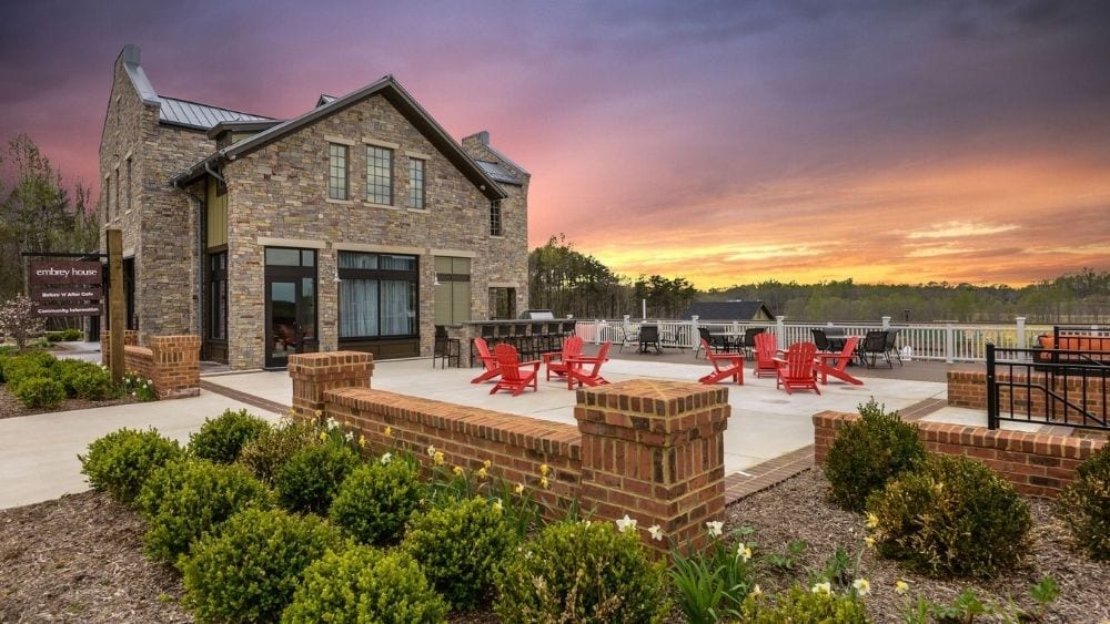 A patio area with chairs, tables, and a BBQ pit.