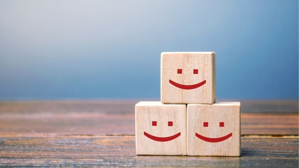 Three blocks stacked on top of each other with friendly red smiley faces on them.